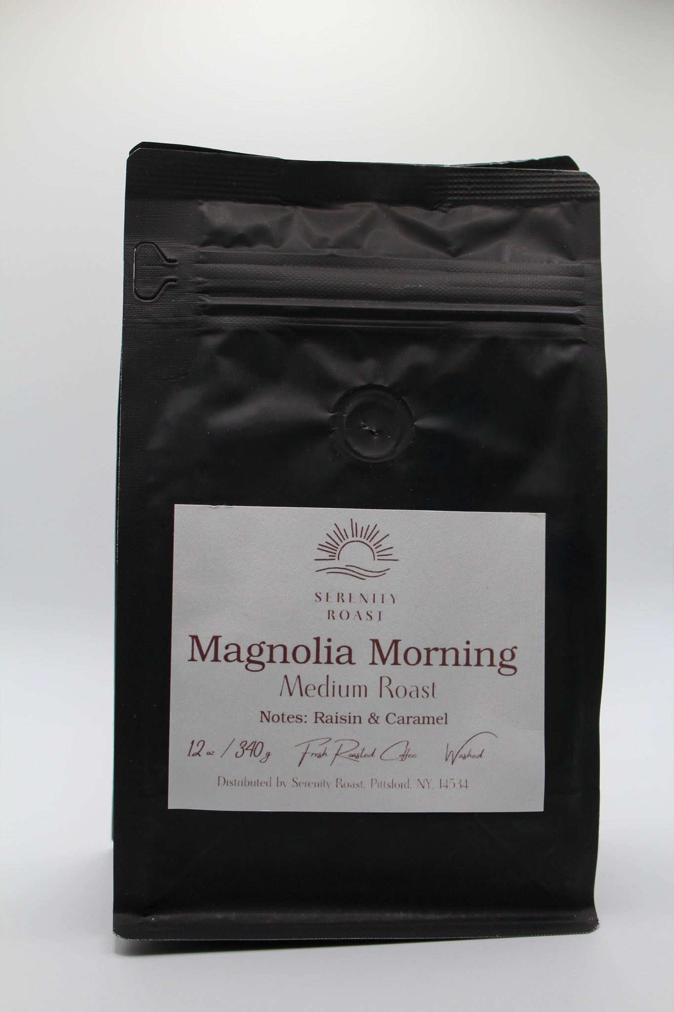 Black coffee bag labeled 'Magnolia Morning' on a white background