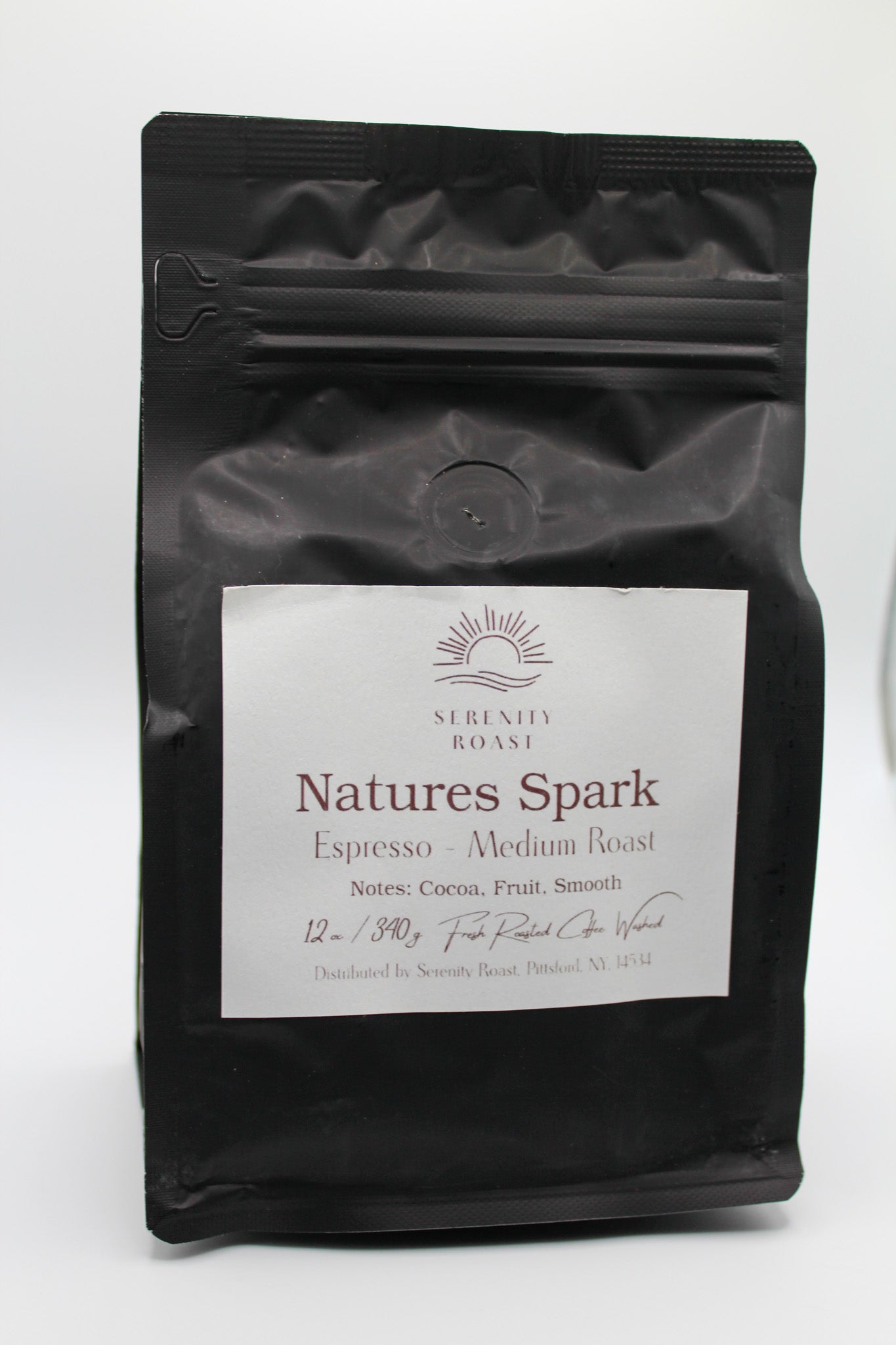 Black coffee bag labeled 'Natures Spark' on a white background